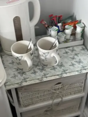 two cups sitting on a table with a counter at Blackbull With Rooms Lower in Cumbernauld