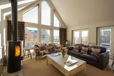 a living room with a couch and a fireplace at Merlin Steading with hot tub in Buchanty