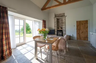 a living room with a table with flowers on it at The Bothy in Buchanty