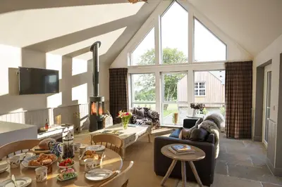 a living room with a lot of windows at Milton Farm in Buchanty