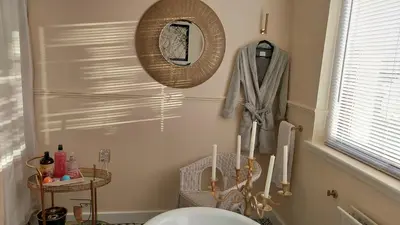 a bathroom with a mirror and a toilet in it at Luxurious room with a private bathtub and shared toilet and kitchen 10mins from City Centre in Bailleston