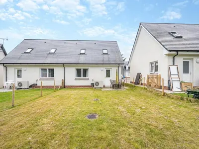 a large white house with a yard in front of it at Riverbank in Lamlash