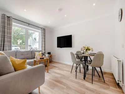 a living room with a couch and a table at Riverbank in Lamlash