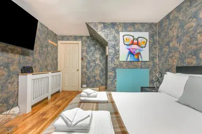 a bedroom with a large bed and a tv at The Old School in Dean Village in Edinburgh