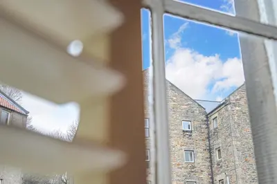 a window with a view of a brick building at The Old School in Dean Village in Edinburgh