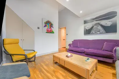 a living room with a purple couch and a coffee table at The Old School in Dean Village in Edinburgh