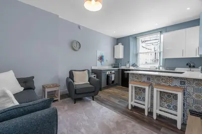 a kitchen and a living room with a fireplace at GuestReady - Lovely nest in the Old Town in Edinburgh