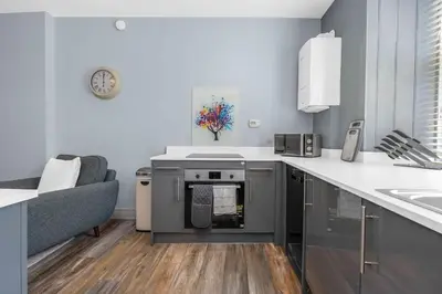 a kitchen with a stove and a couch in it at GuestReady - Lovely nest in the Old Town in Edinburgh