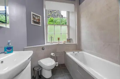 a bathroom with a tub and a toilet and a sink at GuestReady - Lovely nest in the Old Town in Edinburgh