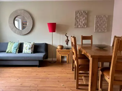 a living room with a blue couch and a table at Beautiful house in Clydebank in Glasgow