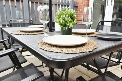 a black table with plates and wine glasses on it at Beautiful house in Clydebank in Glasgow