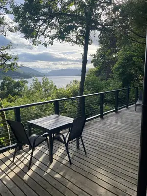 a table and two chairs on a deck with a view at Cherrybrae Cottage in Saint Fillans