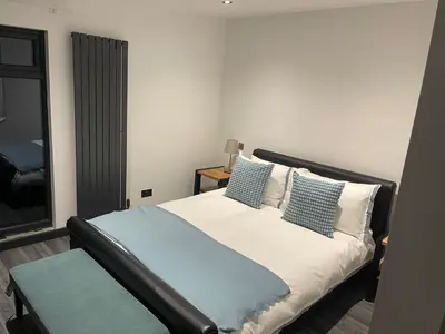 a bedroom with a bed with blue and white pillows at Cherrybrae Cottage in Saint Fillans