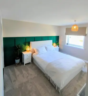 a bedroom with a large white bed and two night stands at Troon Golf and Beach House in Troon