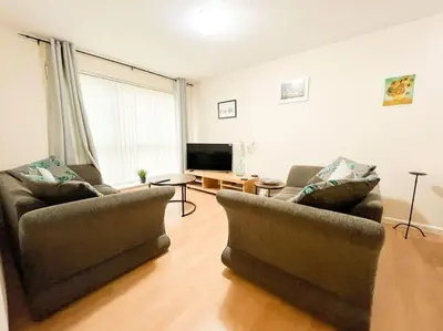 a living room with two couches and a television at Cosy Riverside Home SECC Hydro in Glasgow