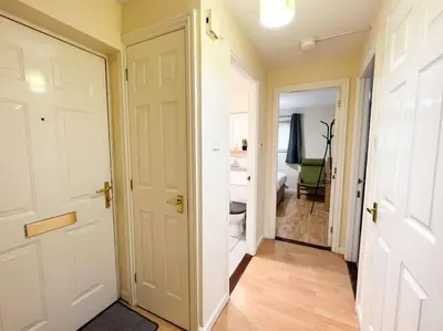 a hallway with a white door and a bedroom at Cosy Riverside Home SECC Hydro in Glasgow