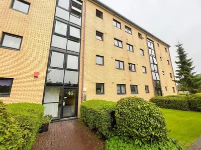 a large brick building with bushes in front of it at Cosy Riverside Home SECC Hydro in Glasgow