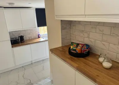 a kitchen with white cabinets and a counter with food on it at Glasgow Central Paradise - Spacious 3- Bed House in Glasgow