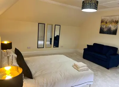 a bedroom with a bed and a blue couch at Glasgow Central Paradise - Spacious 3- Bed House in Glasgow