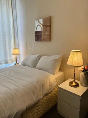 a bedroom with a bed with two lamps and a window at Haymaeket Centro Edinburgh in Edinburgh