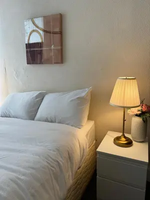 a bedroom with a bed and a lamp on a night stand at Haymaeket Centro Edinburgh in Edinburgh