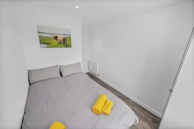 a bedroom with a bed with yellow pillows at Cosy & Comfortable 2BR in Oban - Walk to Waterfront in Oban