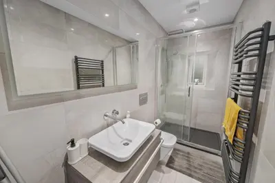 a white bathroom with a sink and a shower at Cosy & Comfortable 2BR in Oban - Walk to Waterfront in Oban