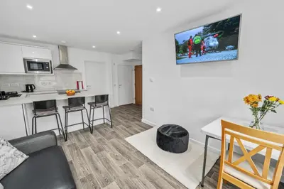 a living room and kitchen with a couch and a table at Cosy & Comfortable 2BR in Oban - Walk to Waterfront in Oban