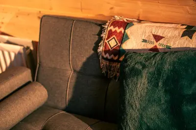 a couch with a rug on the back of it at Green Oak Nature Retreat in Dunfermline