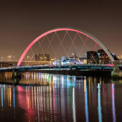 a bridge over the water at night with lights at Beautiful Penthouse in City Centre Location in Glasgow