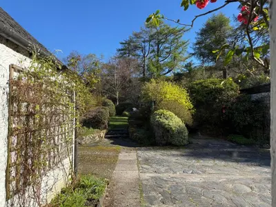 a garden with a fence and a path at Glenrigh House - beautiful garden with old church ruin in Onich