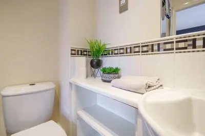 a white bathroom with a toilet and a sink at 5 Bed Finnieston SkyHigh Duplex with Parking in Glasgow