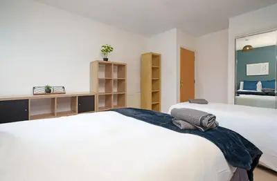 a bedroom with a large white bed and a mirror at 5 Bed Finnieston SkyHigh Duplex with Parking in Glasgow