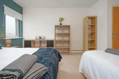 a bedroom with two beds and a desk in it at 5 Bed Finnieston SkyHigh Duplex with Parking in Glasgow