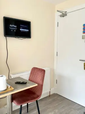 a room with a table and a television on the wall at Edinburgh full house in Edinburgh