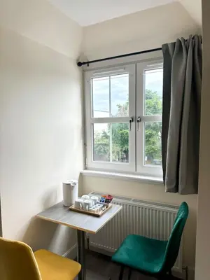a table and a green chair in a room with a window at Edinburgh full house in Edinburgh