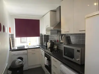 a kitchen with white cabinets and a microwave at Lochrin Apartments by Edinburgh City Apartments in Edinburgh