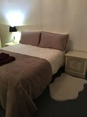 a bedroom with a large bed and a night stand at Beautiful 2 double bedrooms, 2 baths apartment in Port Glasgow