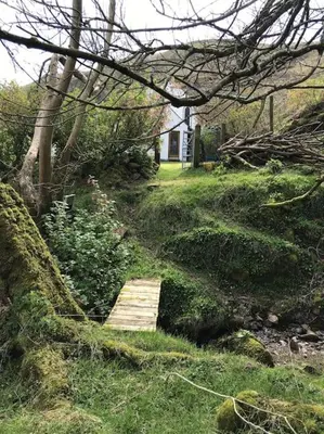 a wooden path in the grass with a house in the background at Coolranny Schoolhouse in Torr