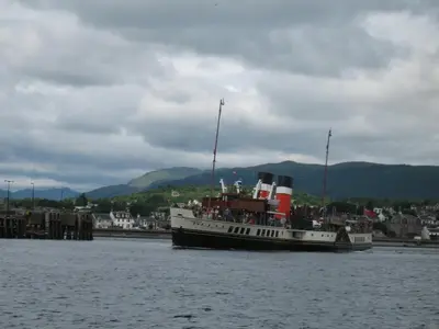 a boat in the water with a city in the background at St Ives Boutique Hotel in Dunoon