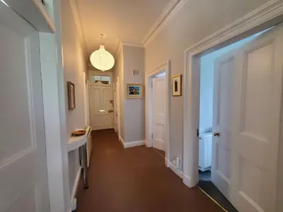 a hallway with a white door and a hallway with a light at Little Bay View in Oban
