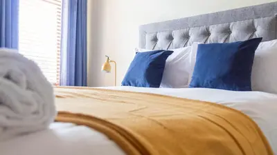 a bedroom with a bed with blue pillows at The Hill in Tillicoultry