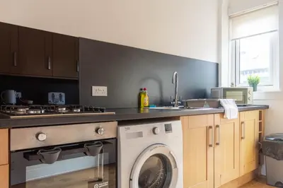 a kitchen with a washing machine and a sink at Beth House in Bathgate