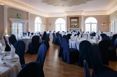 a conference room with tables and chairs and a chandelier at Forrester Park Resort in Dunfermline