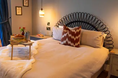 a bedroom with a large bed with a table on it at Firth View 1 - Luxury Cottage with Sea View & Hot Tub, Ayr in Ayr