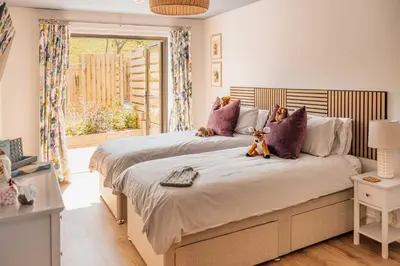 a bedroom with two beds with teddy bears sitting on them at Firth View 1 - Luxury Cottage with Sea View & Hot Tub, Ayr in Ayr