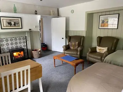 a living room with a bed and a fireplace at The Bothy at Christmas Cottage in Rowardennan