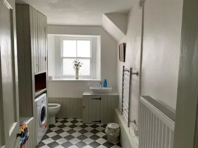 a bathroom with a toilet and a sink and a window at The Bothy at Christmas Cottage in Rowardennan