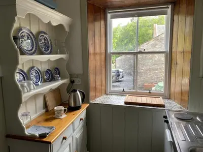 a kitchen with blue and white plates and a window at The Bothy at Christmas Cottage in Rowardennan