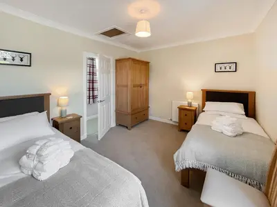 a bedroom with two beds and two night stands at Kilquhanity Cottage in Castle Douglas